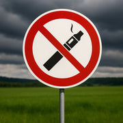 Rotes Verbotsschild mit durchgestrichener E-Zigarette vor bewölktem Himmel - Symbol für das Einweg-Vape-Verbot in Deutschland